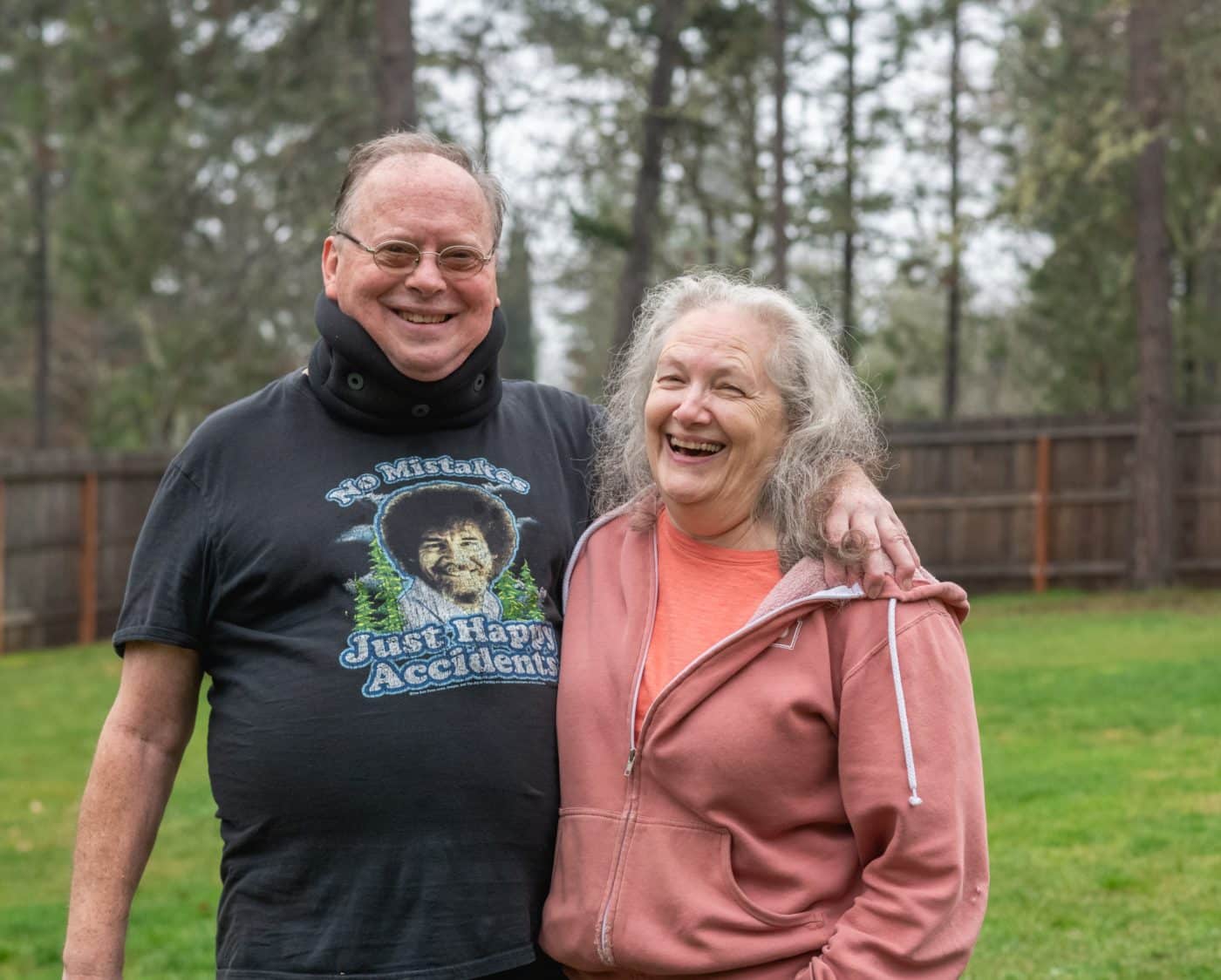 Ron and his wife smile with their arms around each other in an outdoor scene